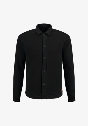 Chemise noire à manches longues, avec un tissu texturé, dotée d'un col, de cinq boutons et de poches latérales. Design simple et fonctionnel.