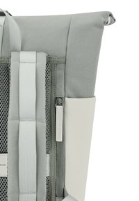 Zaino grigio chiaro con design a roll-top, pannellatura in rete e accenti bianchi a contrasto, dotato di tasca con zip.