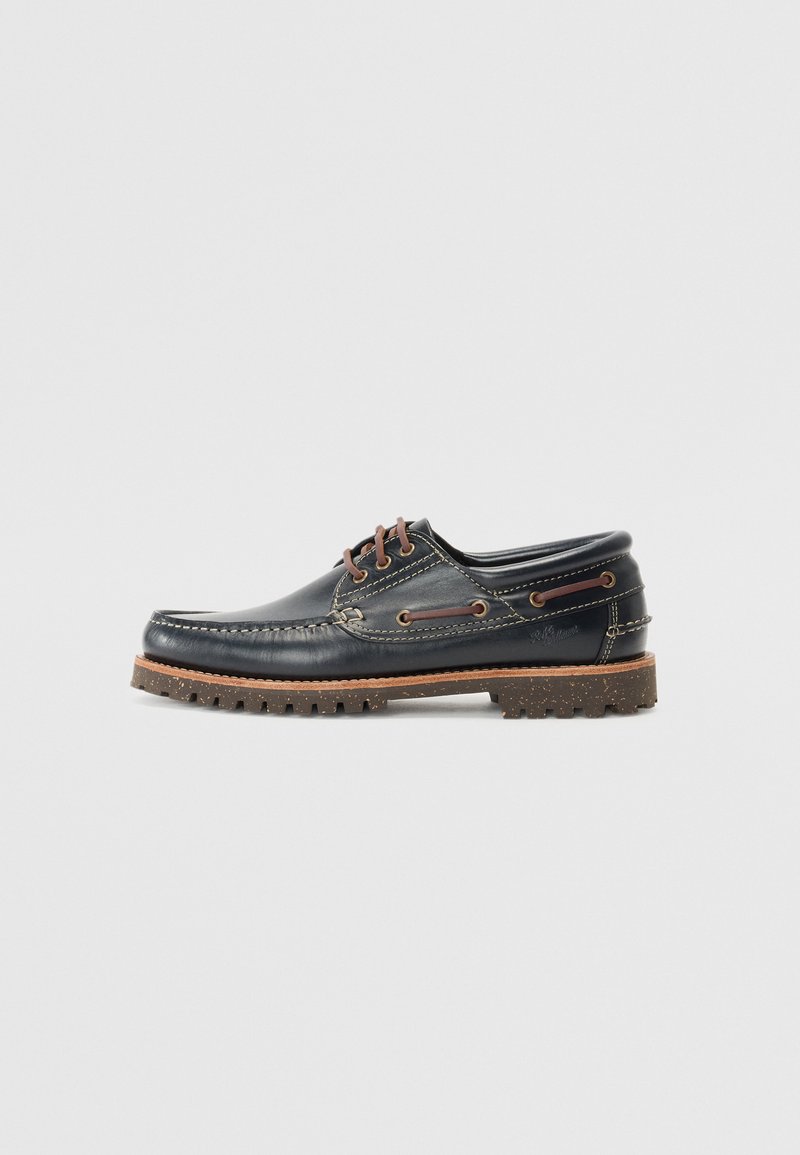 Bateau en cuir marine avec des lacets marron, des œillets encastrés et une semelle rugueuse avec des éclats. Comprend des détails de couture le long du bord supérieur.