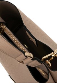 Borsa beige in pelle texturizzata, con hardware dorato e una tasca con zip. L'interno presenta una fodera nera con una finitura liscia.