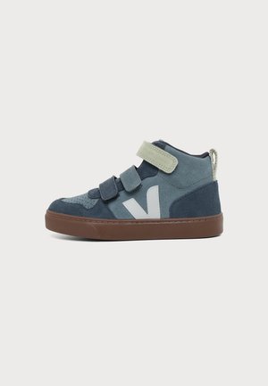 Zapatilla infantil azul y gris de caña alta con tres tiras de velcro, un logo blanco en el lateral y una suela de goma marrón.