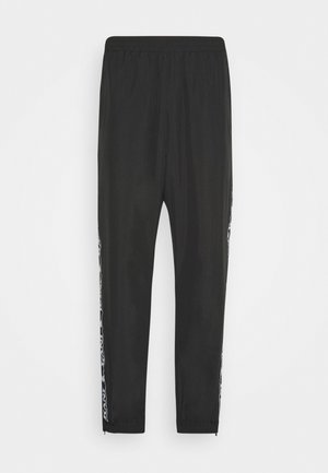 Black athletic pants with an elastic waistband, tapered legs, and contrasting side stripes featuring a graphic design. Smooth texture, lightweight fabric.