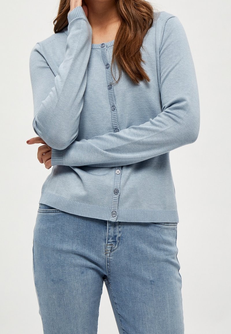 Ljusblå cardigan tillverkad av mjukt stickat tyg, med rund hals, långa ärmar och knäppning framtill med ribbad kant.