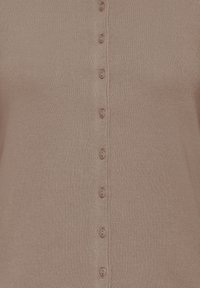 Cardigan boutonné en tissu côtelé doux, couleur mauve clair avec sept boutons assortis sur le devant, présentant une coupe classique et ajustée.