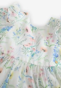 Blumenkleid aus leichtem Stoff mit weißem Hintergrund, Pastell-Wildblumen-Prints, Rüschensäumen und einem gerafften Rock.