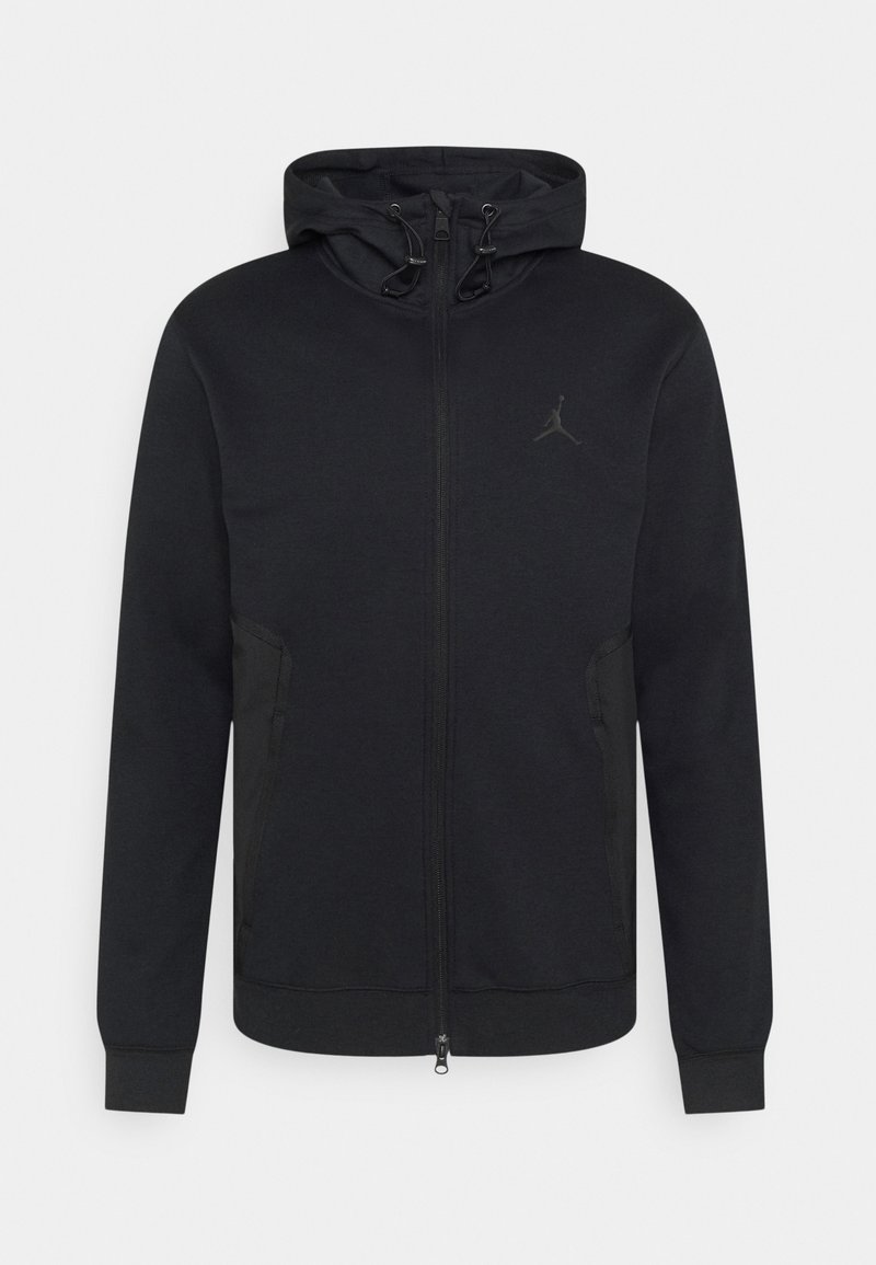 Sweat à capuche zippé noir en tissu doux, avec une poche kangourou, une capuche à cordon et un logo discret sur la poitrine.