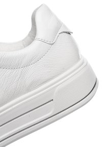 Sneaker bianca con tomaia sintetica testurizzata, collo imbottito, suola in gomma con grip testurizzato e una sottile striscia grigia a contrasto sul lato.