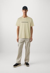Guess Jeans AMERICAN TEE - Marškinėliai su spaudiniu - biscotti