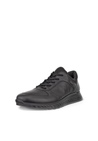 Scarpa sportiva in pelle nera con collo imbottito, allacciatura frontale e suola goffrata, mostrata in vista laterale inclinata.