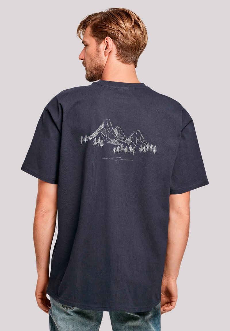 Marineblaue T-Shirt aus Baumwolle mit einem grauen Umrissgrafik von Bergen und Bäumen auf der Rückseite, kurzen Ärmeln und einem Rundhalsausschnitt.