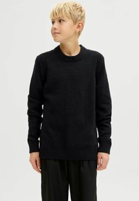 Must musträtik, millel on tekstureeritud viimistlus, soonikkoes crewsuu ja varrukad. Pikad varrukad ja lõdva istuvusega disain. Lihtne ja mitmekülgne stiil.