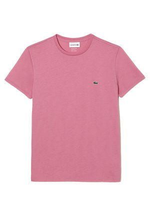 T-shirt en coton rose avec encolure ronde et manches courtes. Présente un petit logo de crocodile vert sur le côté supérieur gauche de la poitrine.