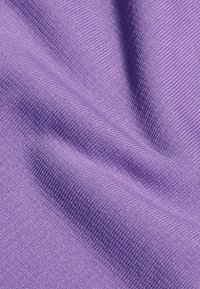 Lila textil med en mjuk, vävd yta, som visar en jämn yta och subtila variationer i nyans och mönster.