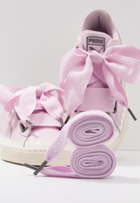 Rosa Sneakers mit übergroßen Satin-Schnürsenkeln, silbernen Akzenten und einer strukturierten weißen Sohle mit gewellten Kanten. Inklusive passender Schnürsenkel.