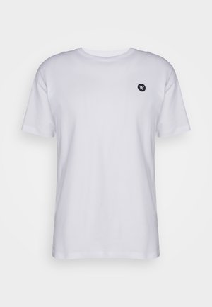 Ensfarvet hvid T-shirt med korte ærmer og rund hals, med en lille sort cirkulær logo på venstre bryst, vist mod en neutral baggrund.