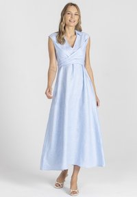 Jasnoniebieska, bezrękawnikowa maxi sukienka z fasonem kopertowym, dekoltem w serek i gładką fakturą lnu. Posiada zwiewną spódnicę i proste akcenty.