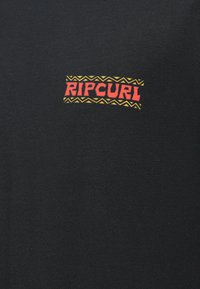 Czarna bawełniana koszulka z grafiką logo „RIPCURL” w wielu kolorach, z czerwonymi literami i żółtą zygzakowatą ramką. Gładka tekstura.