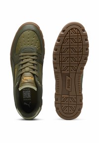 Baskets synthétiques vertes avec embout perforé, détails texturés et accents beige. Dotées d'une semelle extérieure en caoutchouc avec un motif de bande de roulement.