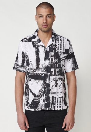 Cămașă cu mâneci scurte, imprimeu abstract alb-negru, material ușor, design cu guler, croi lejer, textură și modele vizibile.