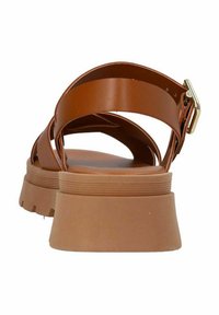 Bruine nep-lederen sandalen met een kruisbandontwerp, platte zool en gouden gesp detail. Dikke rubberen zool met geribbelde textuur.