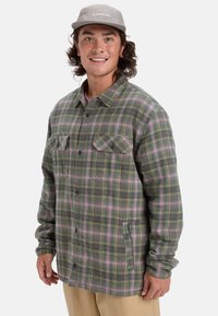 Karierte Flanellbluse mit grünen, rosa und gelben Tönen; Knopfverschluss, zwei Brusttaschen und lockere Passform. Baumwollmaterial, weiche Textur.