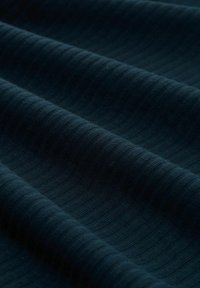 Dunkelblaues Gewebe mit einem strukturierten, gerippten Muster, das sanfte Wellen und subtile Farbvariationen zeigt. Glattes, flexibles Baumwollmaterial.