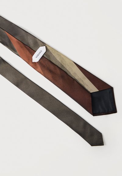 Μεταξωτή γραβάτα με διαγώνιες ρίγες σε καφέ, μπεζ και γκρι αποχρώσεις, με ετικέτα Versace στο εσωτερικό.