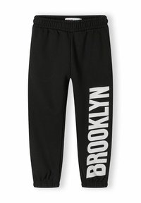 Svarta sweatpants med elastisk midja, smalnande ben och en djärv vit "BROOKLYN" grafisk design tryckt vertikalt på vänster sida.