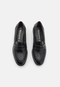 Paire de mocassins penny en cuir noir avec détails cousus vus de dessus sur fond blanc, taille 37 avec semelles intérieures de marque.