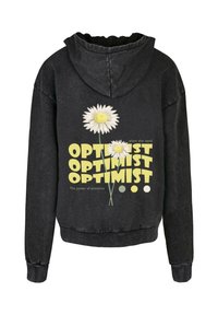 Felpa nera con vestibilità rilassata, decorata con margherite bianche e il testo "OPTIMIST" in giallo. Tessuto morbido con cappuccio regolabile e polsini a costine.