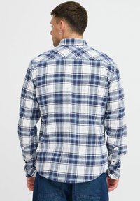 Camicia a maniche lunghe a quadri con motivi blu navy, bianco e azzurro, realizzata in tessuto leggero, con colletto classico e polsini con bottone.