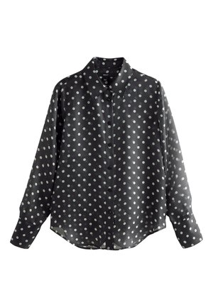 Schwarze langärmelige Bluse mit weißen Punkten und klassischem Kragen, vor weißem Hintergrund dargestellt.