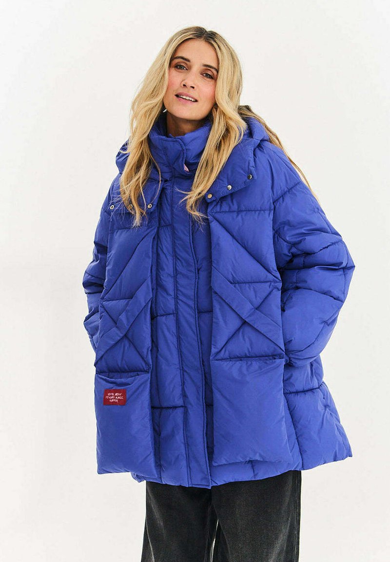 Prošívaná bunda v jasně modré barvě s vysokým límcem, zapínáním na patentky, šikmým prošitím a dvěma předními kapsami.