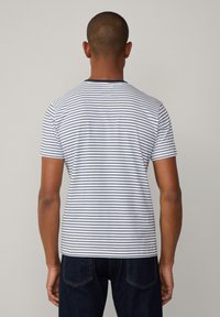 Camiseta de rayas de manga corta, con tejido blanco y rayas horizontales en navy, y cuello redondo. Textura suave.