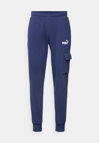 Dunkelblaue Sweatpants aus weichem Stoff, mit schmal zulaufendem BeinDesign, gerippten Bündchen und einer seitlichen Cargo-Tasche mit Klettverschluss.