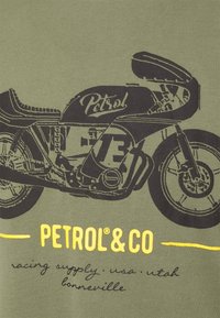 Camiseta de color verde oscuro con un gráfico de una motocicleta negra y el texto "Petrol". Texto impreso en amarillo debajo que dice "PETROL & CO" y detalles adicionales.
