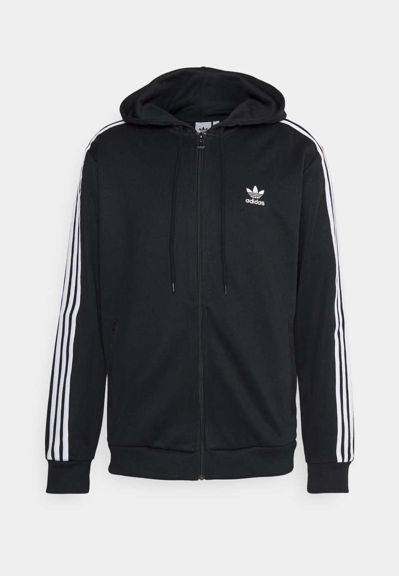 Černá mikina Adidas s předním zipem, bílý trojpruhový design na rukávech, logo Adidas na hrudi a stahovací kapuce.