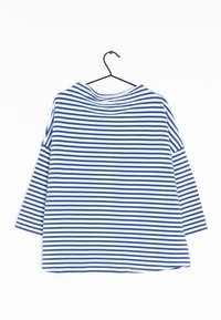 Randig skjorta med blåa och vita horisontella ränder, avslappnad passform, bred halsringning och trekvartärmar. Hänger på en svart krok.