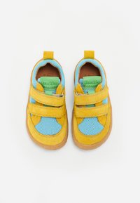 Chaussures en daim jaunes avec des côtés en maille bleue, dotées de deux sangles à boucle et d'un accent logo vert sur la languette. Semelle en caoutchouc marron.