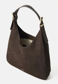 Bruine suède schoudertas met een gebogen vorm en goudkleurige details. Voorzien van een enkele leren riem en een ruim interieur.