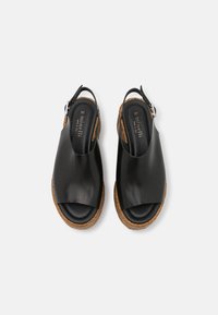 Černé kožené sandály na podpatku s otevřenou špičkou a elastickým páskem, korkovou podešví a hladkým povrchem. Velikost 37 označena uvnitř.