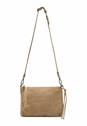 Sac bandoulière en daim beige avec sangle réglable et fermeture éclair, doté de pompons décoratifs sur les tirettes et de détails de couture subtils.