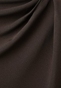 Hnedá tkanina s hladkou textúrou; obsahuje jemné záhyby a nenápadný lesk, čo vytvára účinok zavesenia.