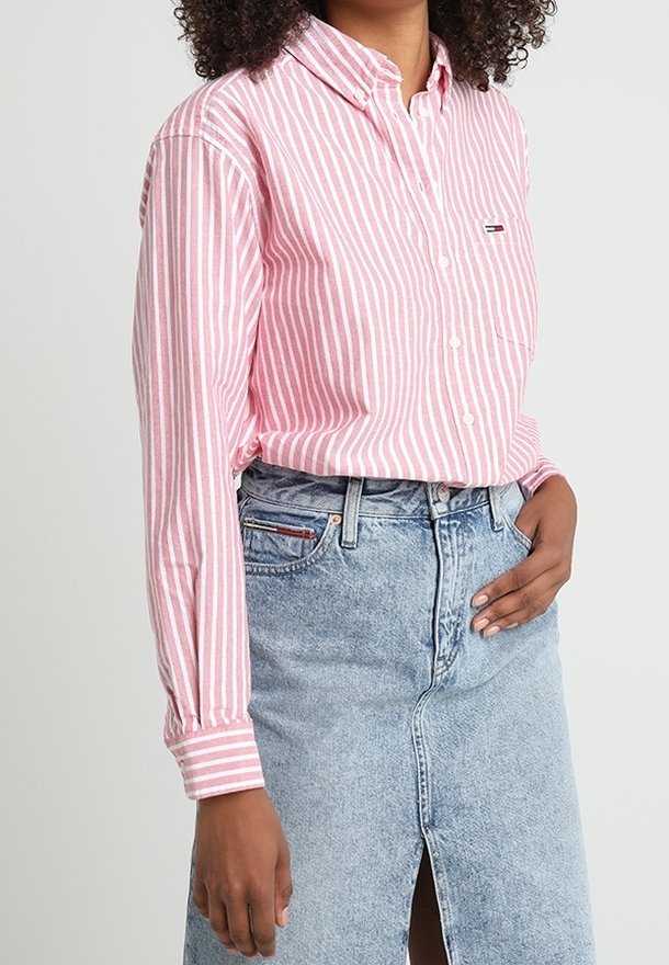 Roze en wit gestreepte blouse met lange mouwen en een borstzak, gecombineerd met een lichtblauwe denim rok met een split aan de voorkant.