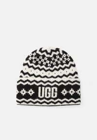 Czarno-biała dziana czapka z wzorami w zygzak i diamenty, z logo "UGG" na mankiecie. Miękka wełniana tekstura.