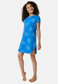 Blå kortærmet kjole lavet af blød stof, med hvide skildpaddetryk og sideslids for komfort og let bevægelighed.