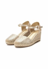 Cuñas de esparto beige con parte superior sintética perforada y tira de tobillo. Tacón de cuña envuelto en yute. Textura suave y diseño de punta redondeada.