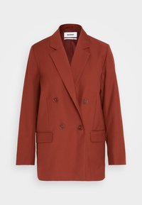 Blazer double boutonnage couleur rouille avec revers crantés, quatre boutons, deux poches avant à rabat et manches longues, étiquette "Weekday".