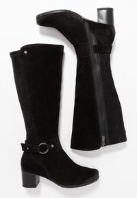 Botas negras de ante hasta la rodilla con cierre de cremallera, acento de hebilla circular y tacón apilado. Textura suave con detalles de costura sutiles.