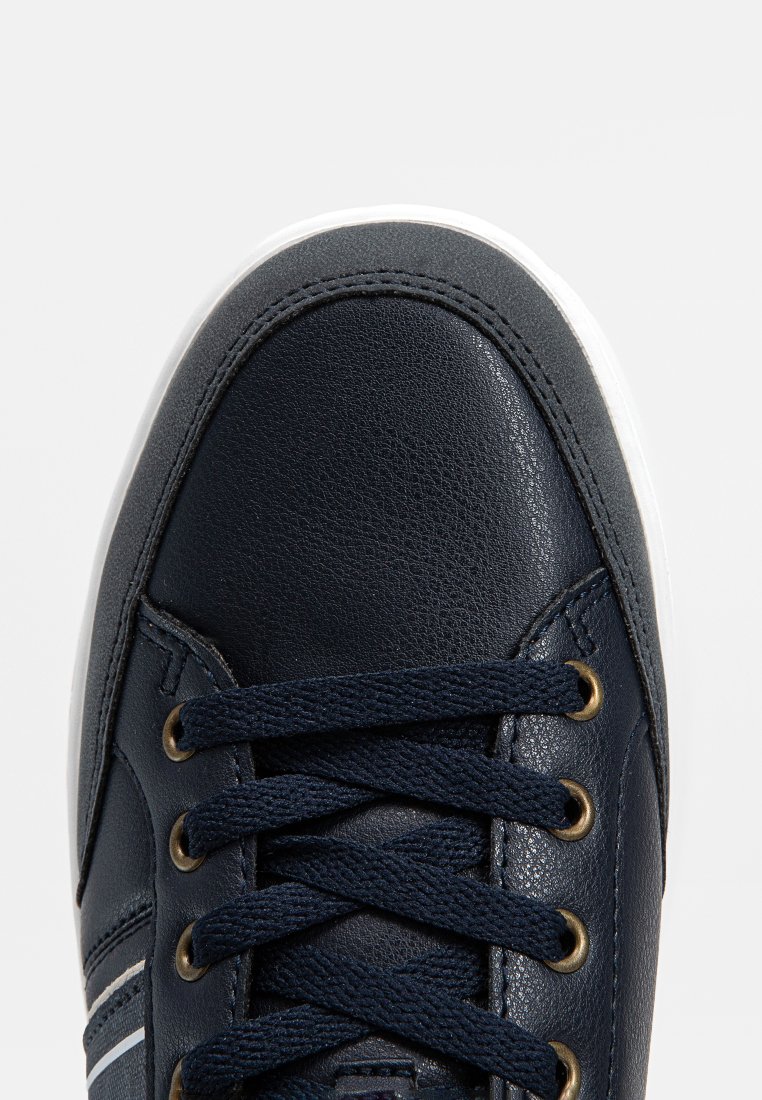Marineblauwe leren sneaker met een witte zool, voorzien van gouden oogjes en blauwe veters, een gestructureerd oppervlak en gestikte accenten op de bovenkant.